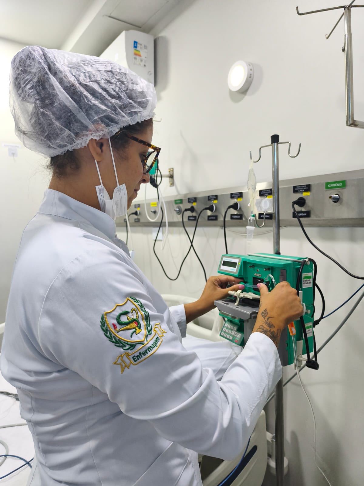Aluna operando bomba infusora, equipamento de terapia intensiva